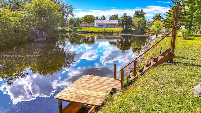view of dock featuring a lawn and a water view