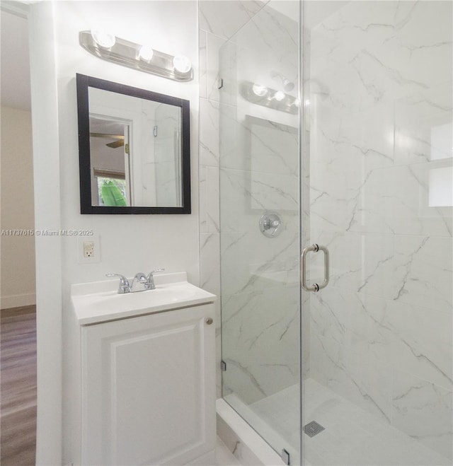 bathroom featuring vanity, hardwood / wood-style flooring, and a shower with door