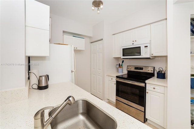 kitchen featuring white cabinetry, sink, white appliances, and light stone countertops