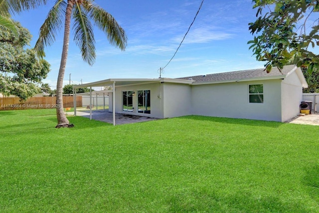 rear view of property featuring a patio and a lawn