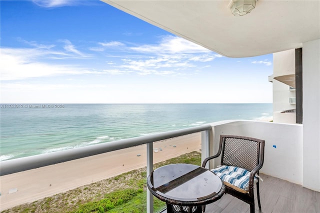 balcony with a water view and a beach view