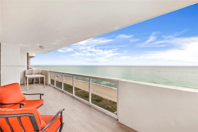 balcony with a water view and a beach view