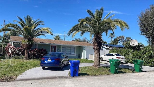 single story home featuring a garage and a front yard