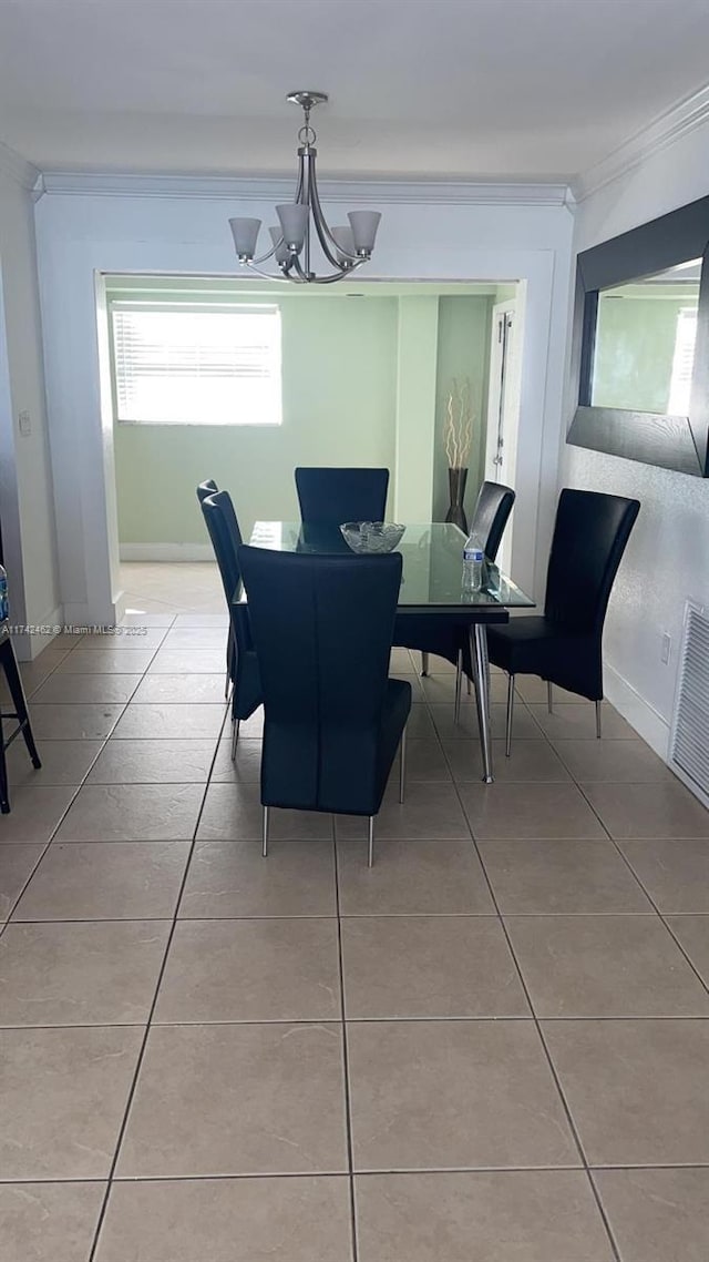 tiled dining room featuring crown molding, an inviting chandelier, and a wealth of natural light