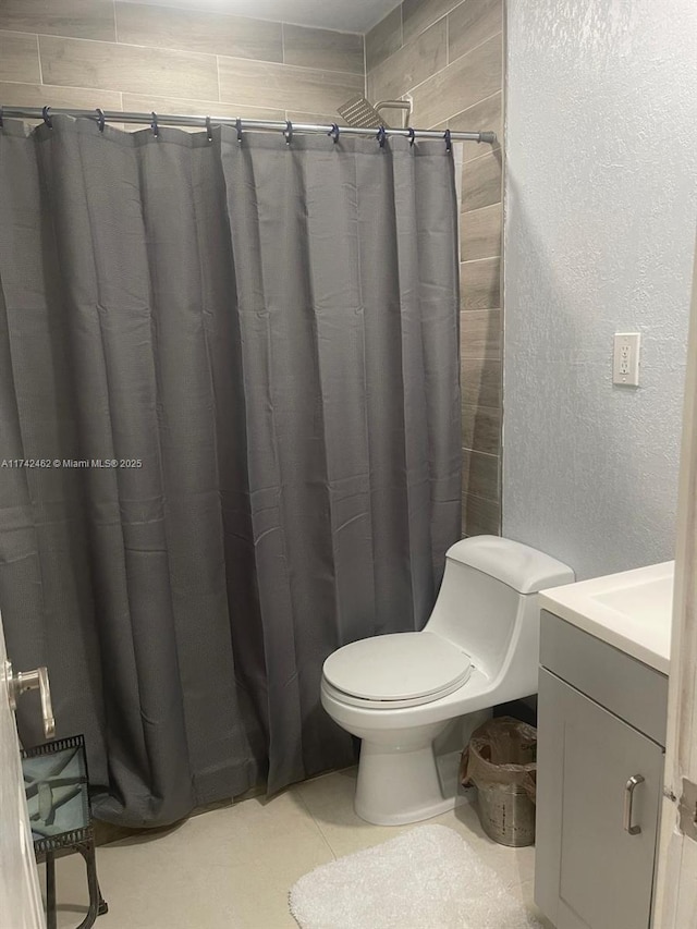 bathroom featuring tile patterned flooring, vanity, curtained shower, and toilet