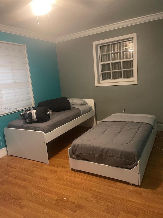 bedroom featuring light hardwood / wood-style flooring and ornamental molding