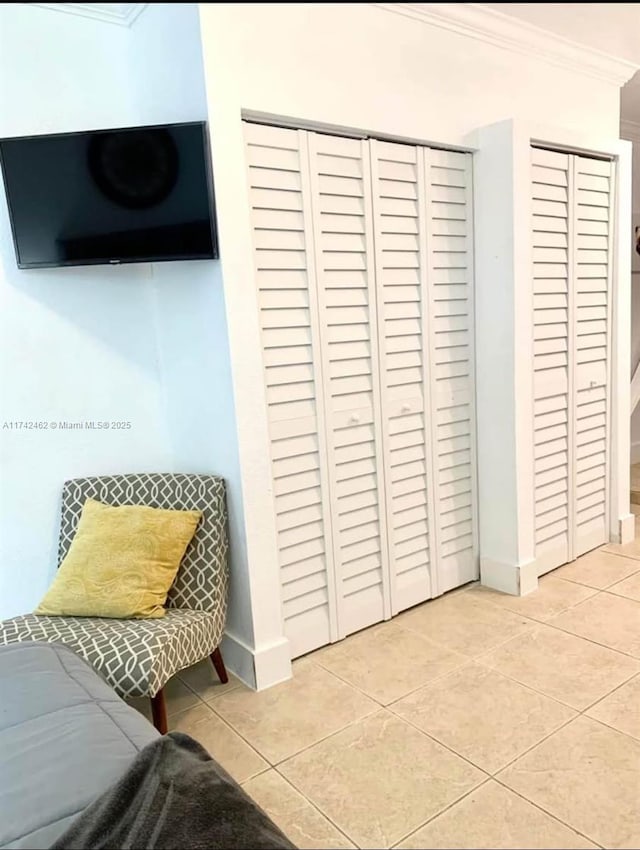 interior space with ornamental molding and light tile patterned floors