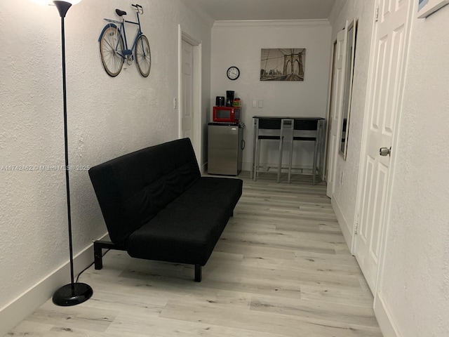 living area featuring crown molding and light wood-type flooring