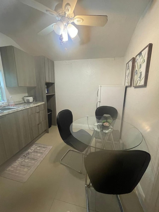 dining area with sink, light tile patterned floors, and ceiling fan