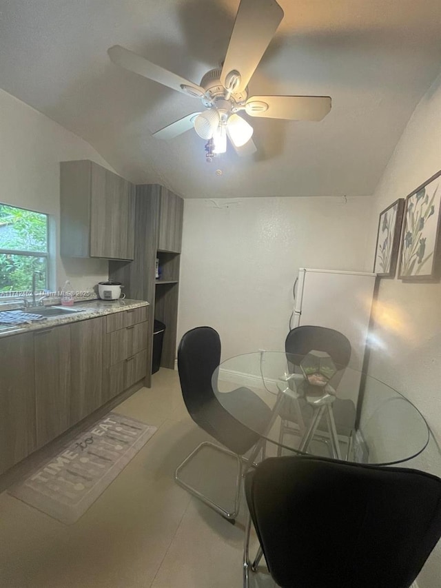 dining space with ceiling fan, lofted ceiling, and sink