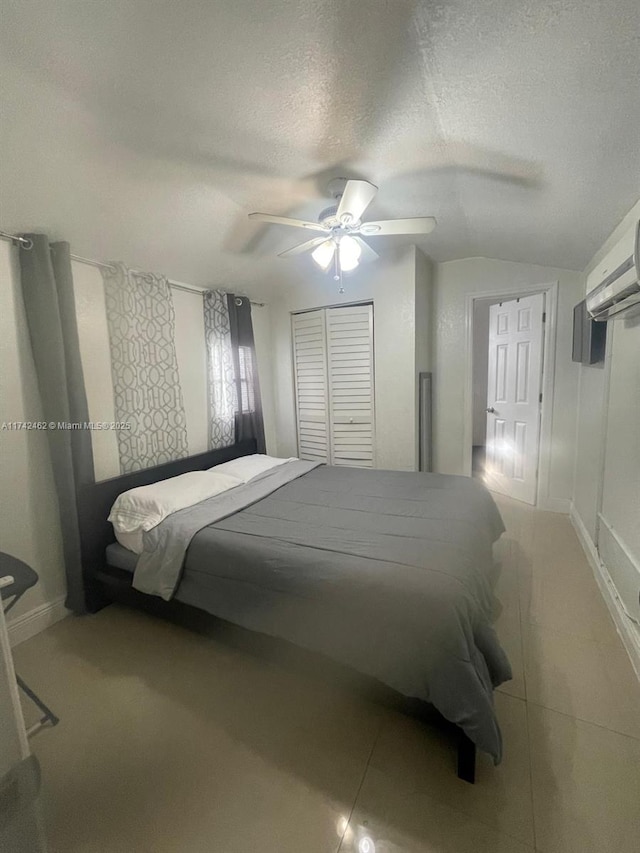 bedroom with ceiling fan, an AC wall unit, lofted ceiling, and a textured ceiling