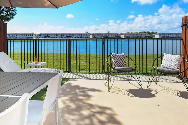 view of patio with a water view and a balcony