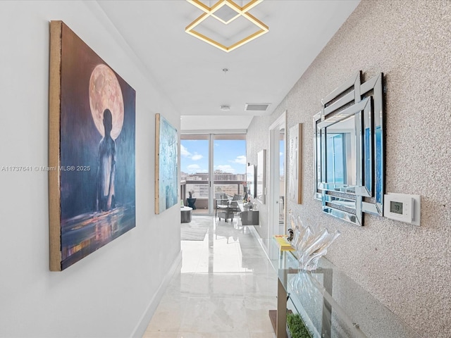 hall featuring visible vents, baseboards, and marble finish floor