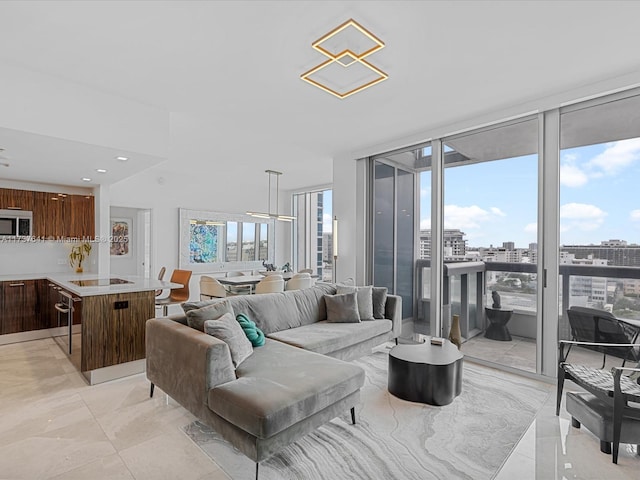 living area featuring floor to ceiling windows, a city view, marble finish floor, and recessed lighting