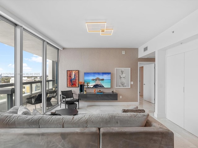 living room with expansive windows, visible vents, and tile patterned flooring