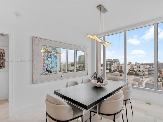 dining area with plenty of natural light, light tile patterned floors, a view of city, and baseboards