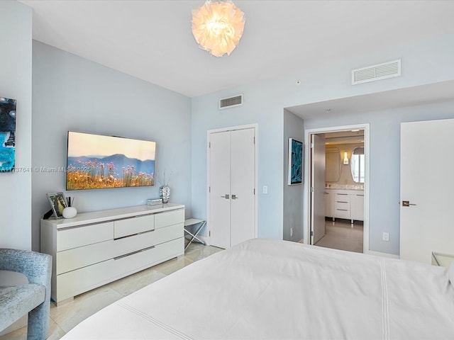 bedroom featuring visible vents, ensuite bath, and light tile patterned floors