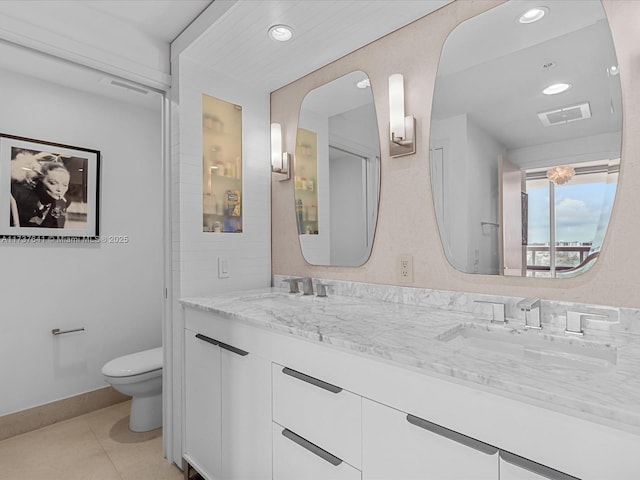 bathroom with vanity, tile patterned flooring, and toilet