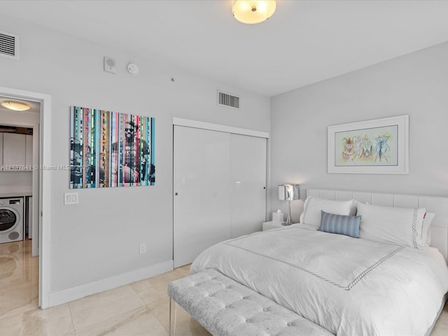 bedroom with visible vents, washer / clothes dryer, a closet, and baseboards