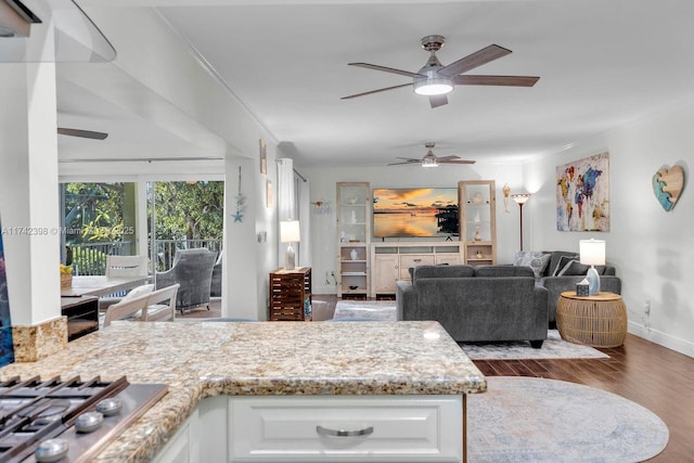 kitchen featuring stainless steel gas stovetop, white cabinetry, dark wood-style flooring, and crown molding