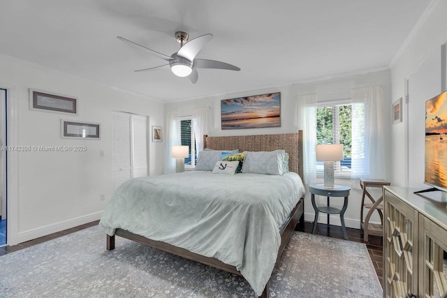 bedroom with ceiling fan, baseboards, ornamental molding, a closet, and dark wood-style floors