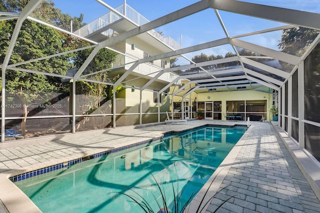 outdoor pool with a patio area and glass enclosure