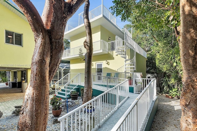 view of side of property with a lanai, a swimming pool, and stucco siding