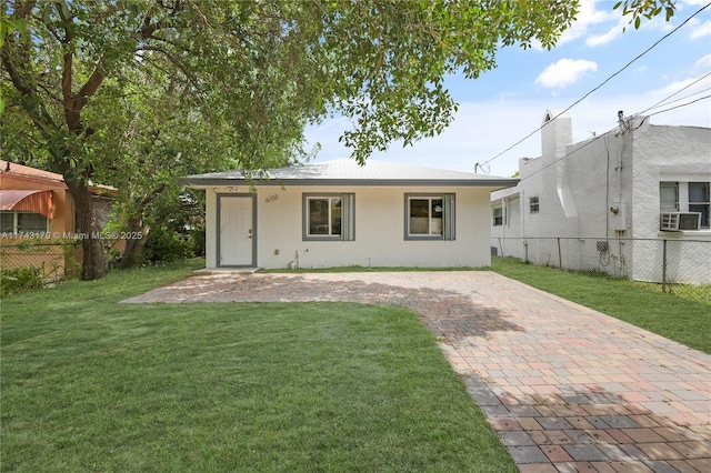 rear view of property featuring cooling unit and a lawn