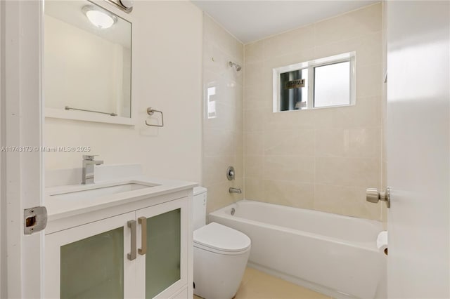 full bathroom featuring tiled shower / bath, vanity, and toilet