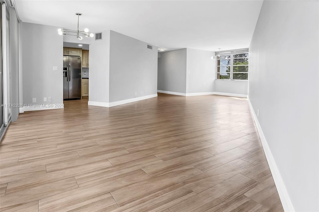 6911 Environ Blvd Unit 5L, Lauderhill, FL 33319 - spare room featuring a chandelier and light wood finished floors