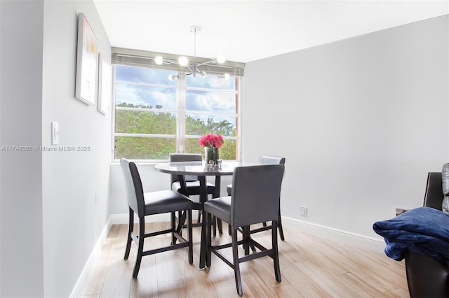 6911 Environ Blvd Unit 5L, Lauderhill, FL 33319 - dining space with light wood-style flooring, baseboards, and an inviting chandelier