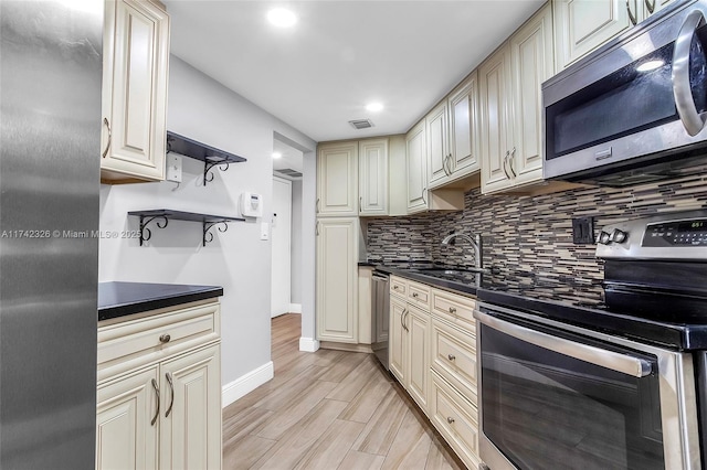 6911 Environ Blvd Unit 5L, Lauderhill, FL 33319 - kitchen with stainless steel appliances, dark countertops, tasteful backsplash, cream cabinetry, and recessed lighting