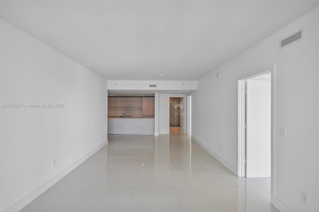 unfurnished room with sink and light tile patterned floors