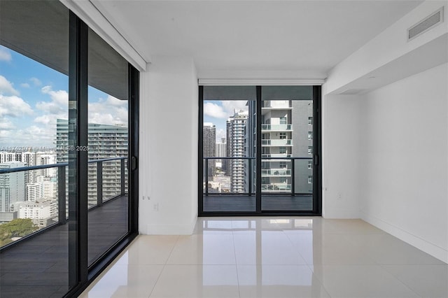 empty room featuring light tile patterned floors and a wall of windows