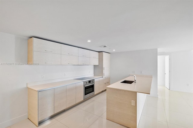 kitchen featuring sink, light tile patterned floors, a center island, black electric cooktop, and stainless steel oven