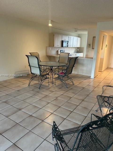 dining space with light tile patterned flooring and a textured ceiling