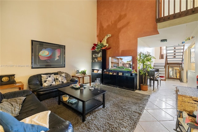 living room with a towering ceiling and light tile patterned floors