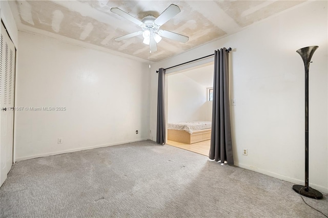 unfurnished bedroom featuring ceiling fan and light carpet