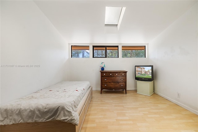 bedroom with light wood-type flooring and a skylight