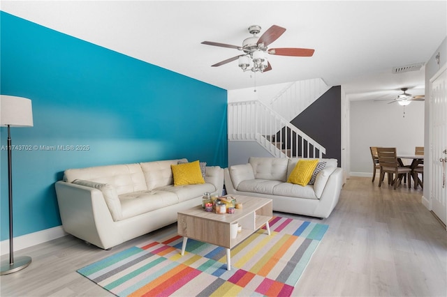 living room with ceiling fan and light hardwood / wood-style flooring