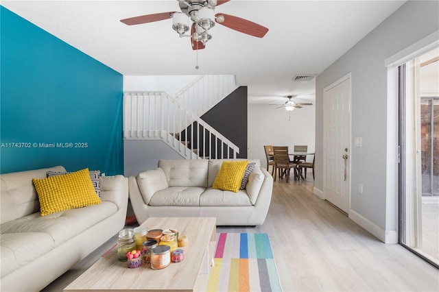 living room featuring light hardwood / wood-style flooring and ceiling fan