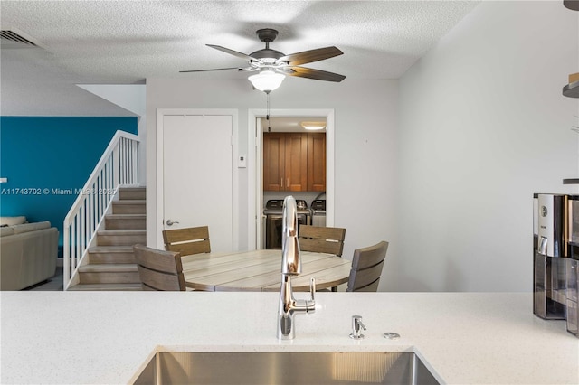 kitchen featuring sink, a textured ceiling, and ceiling fan