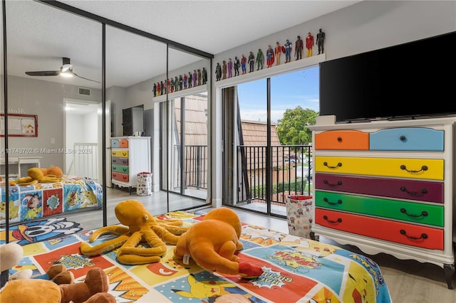 bedroom with access to outside, a textured ceiling, and light hardwood / wood-style flooring