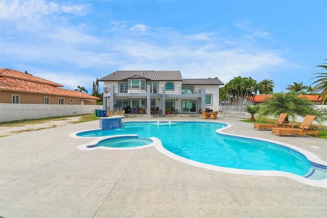 view of pool with an in ground hot tub, pool water feature, and a patio area