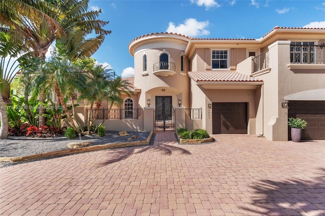 mediterranean / spanish-style home with a garage and a balcony