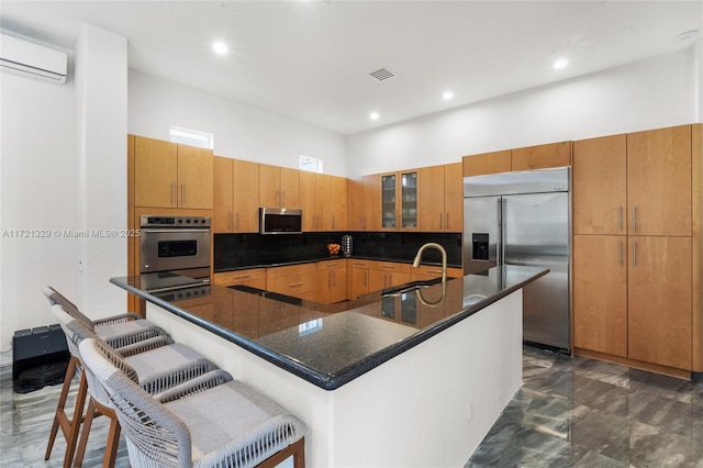 kitchen with a large island, sink, a breakfast bar area, stainless steel appliances, and tasteful backsplash