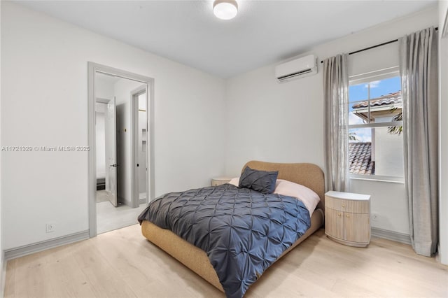 bedroom with light hardwood / wood-style flooring and a wall unit AC