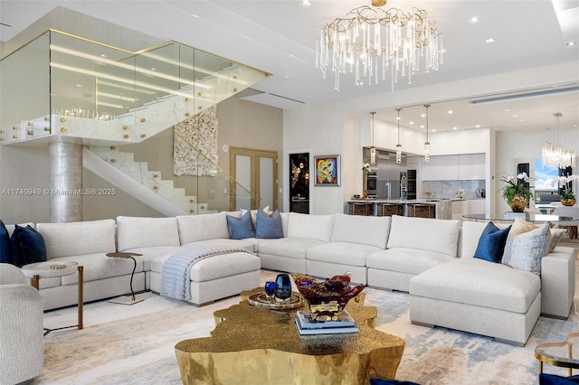 living area featuring a chandelier, recessed lighting, a towering ceiling, and stairway