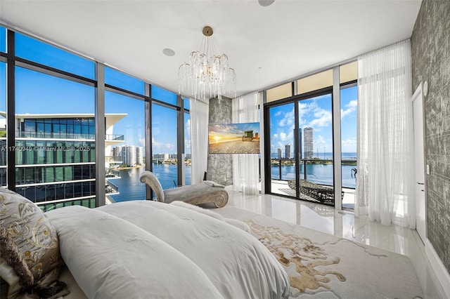 bedroom with a water view, access to outside, an inviting chandelier, and floor to ceiling windows