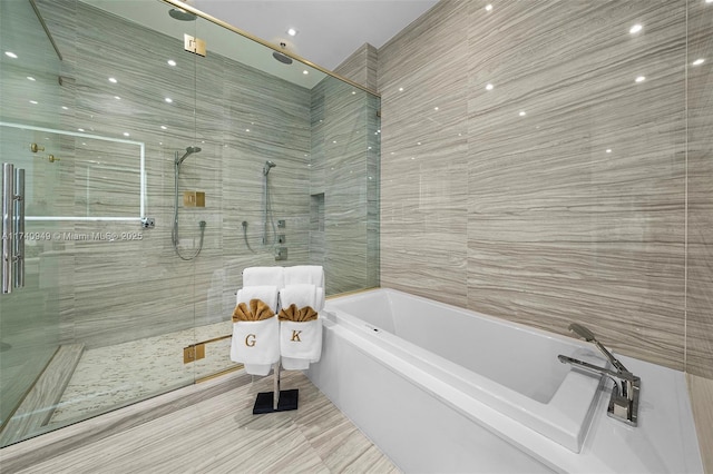 5000 Island Estates Dr Unit Ph1508, Aventura, FL 33160 - bathroom featuring a bath, a stall shower, and tile walls